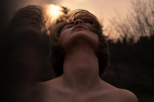 Moody portrait of a woman in nature reflecting emotion at dusk.